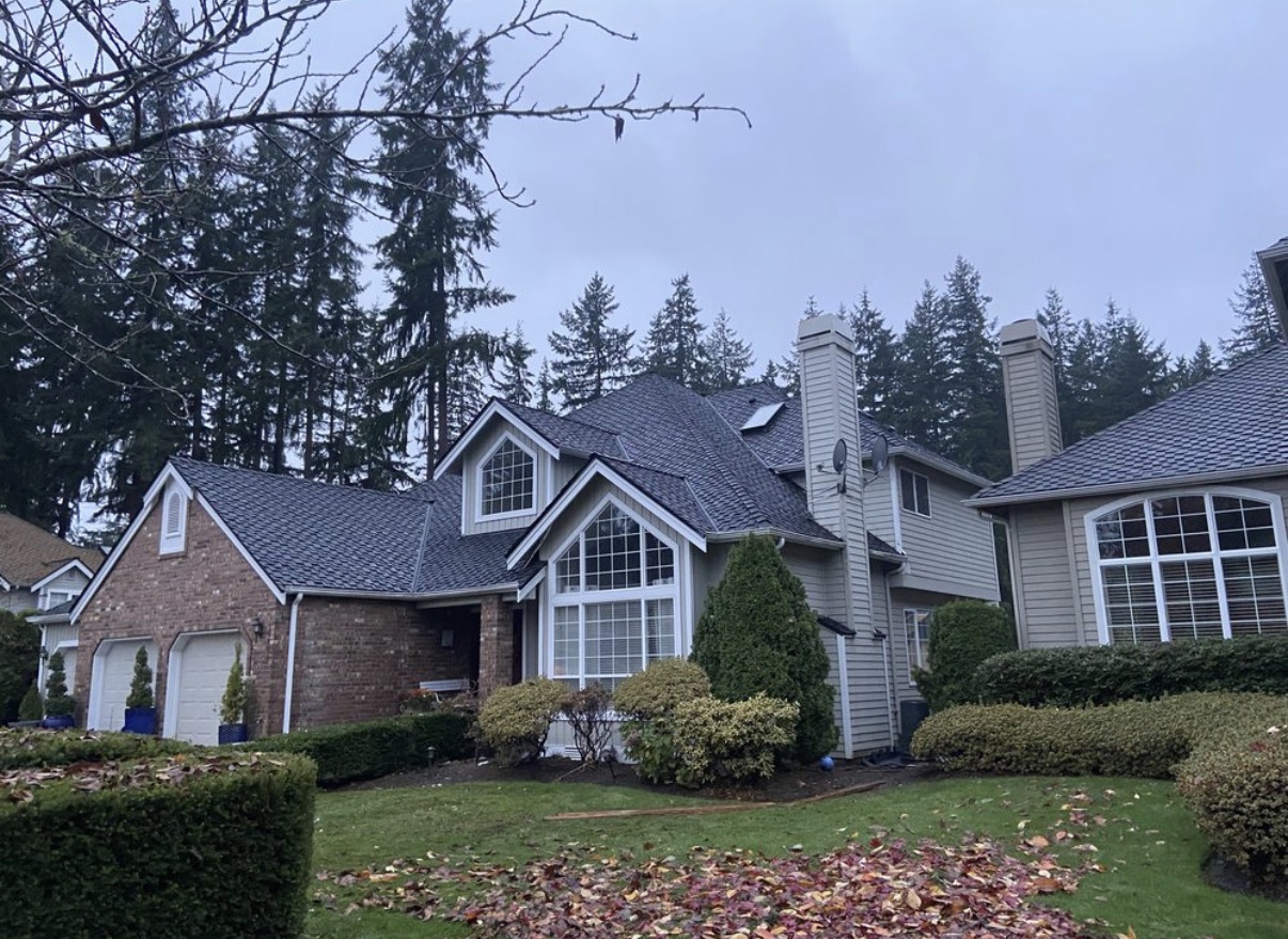 Completed dark architectural shingle roof on a two-story home