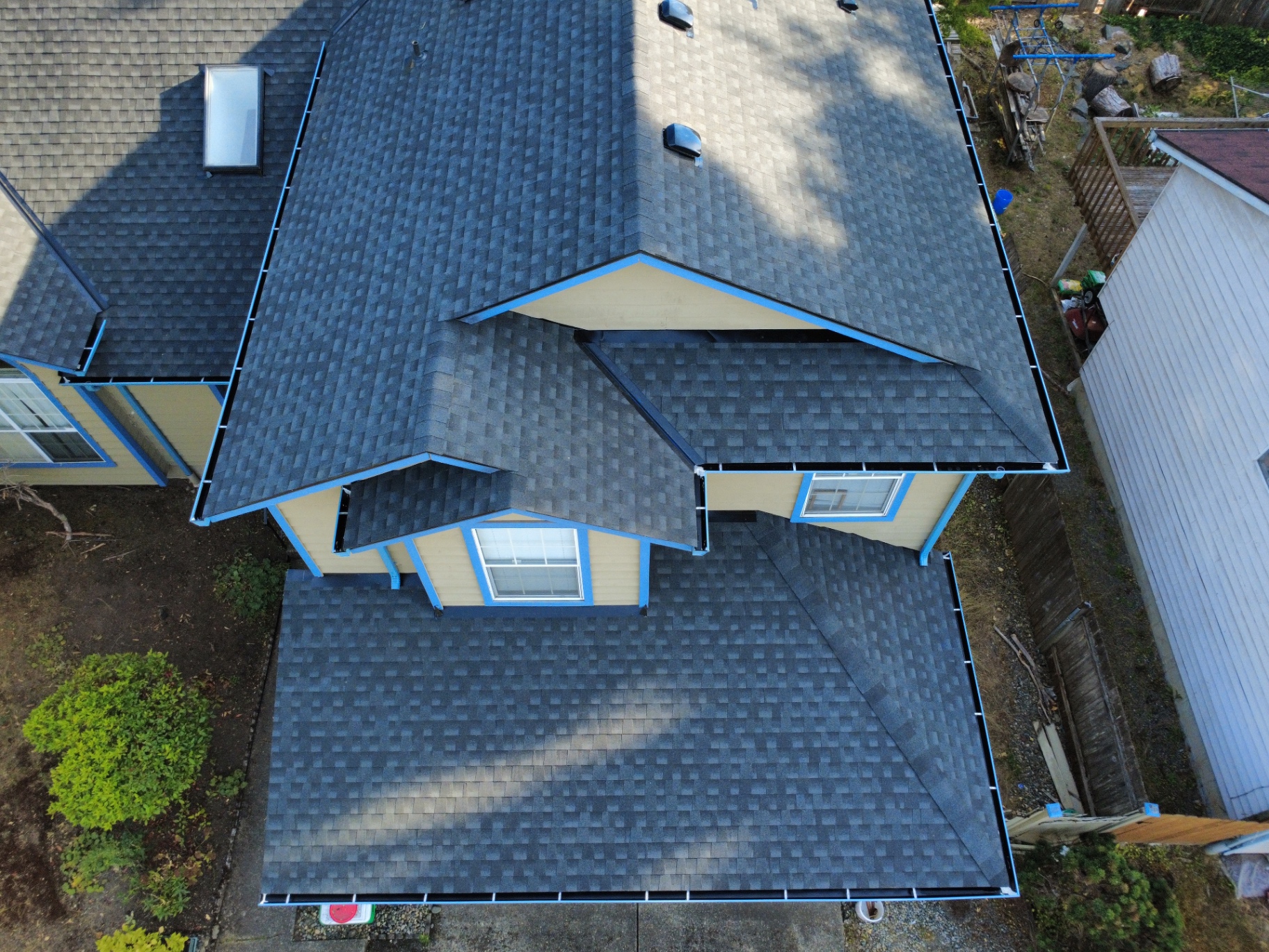 Aerial view of a completed residential roof with professionally installed gutters
