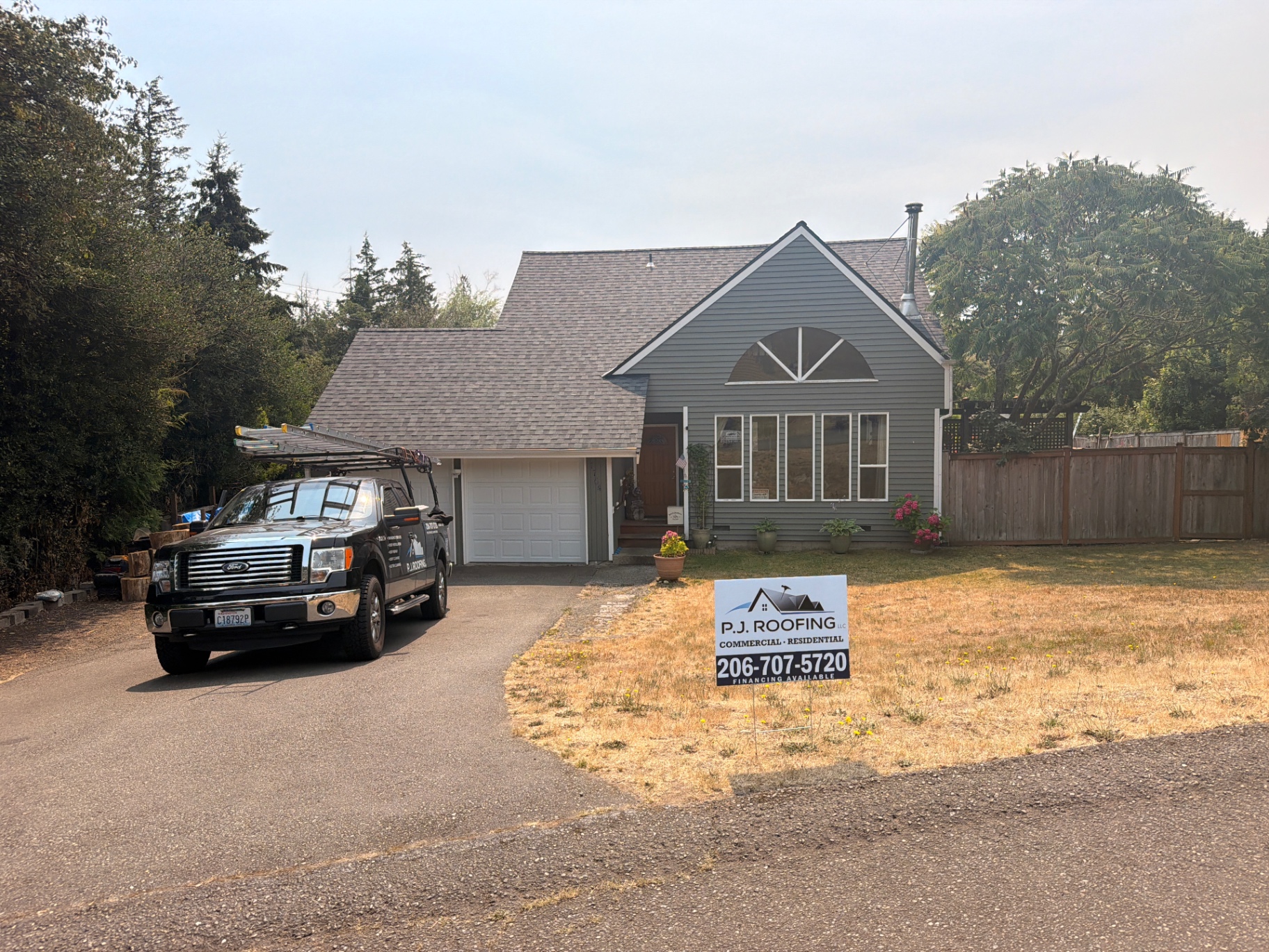 P.J Roofing truck and yard sign at a completed shingle roof replacement