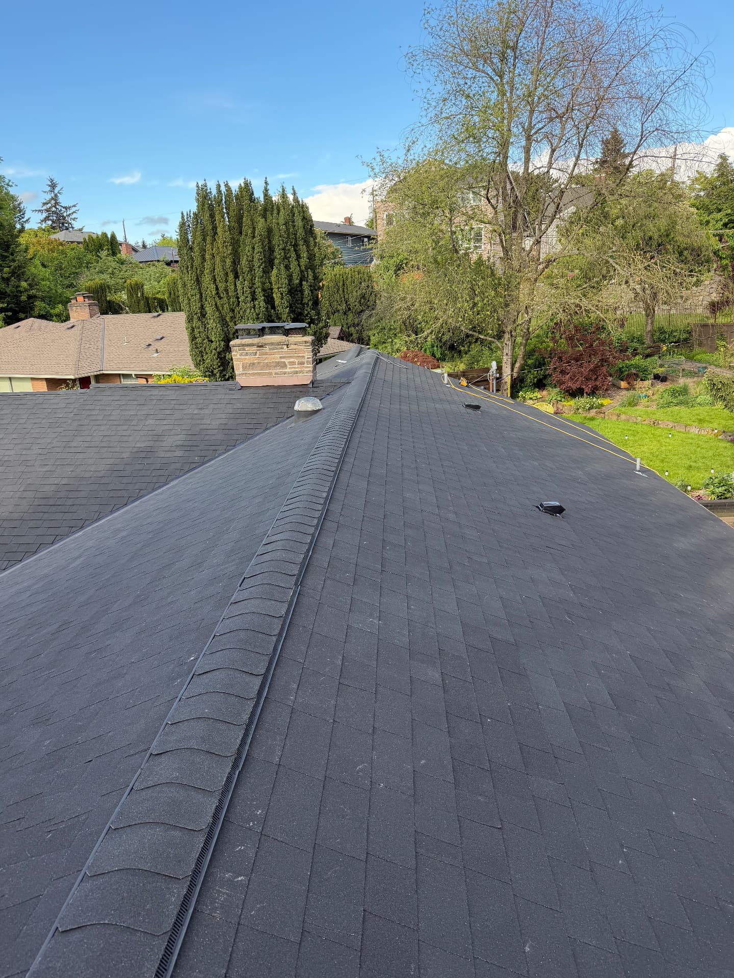Newly installed dark architectural shingle roof with ridge vent
