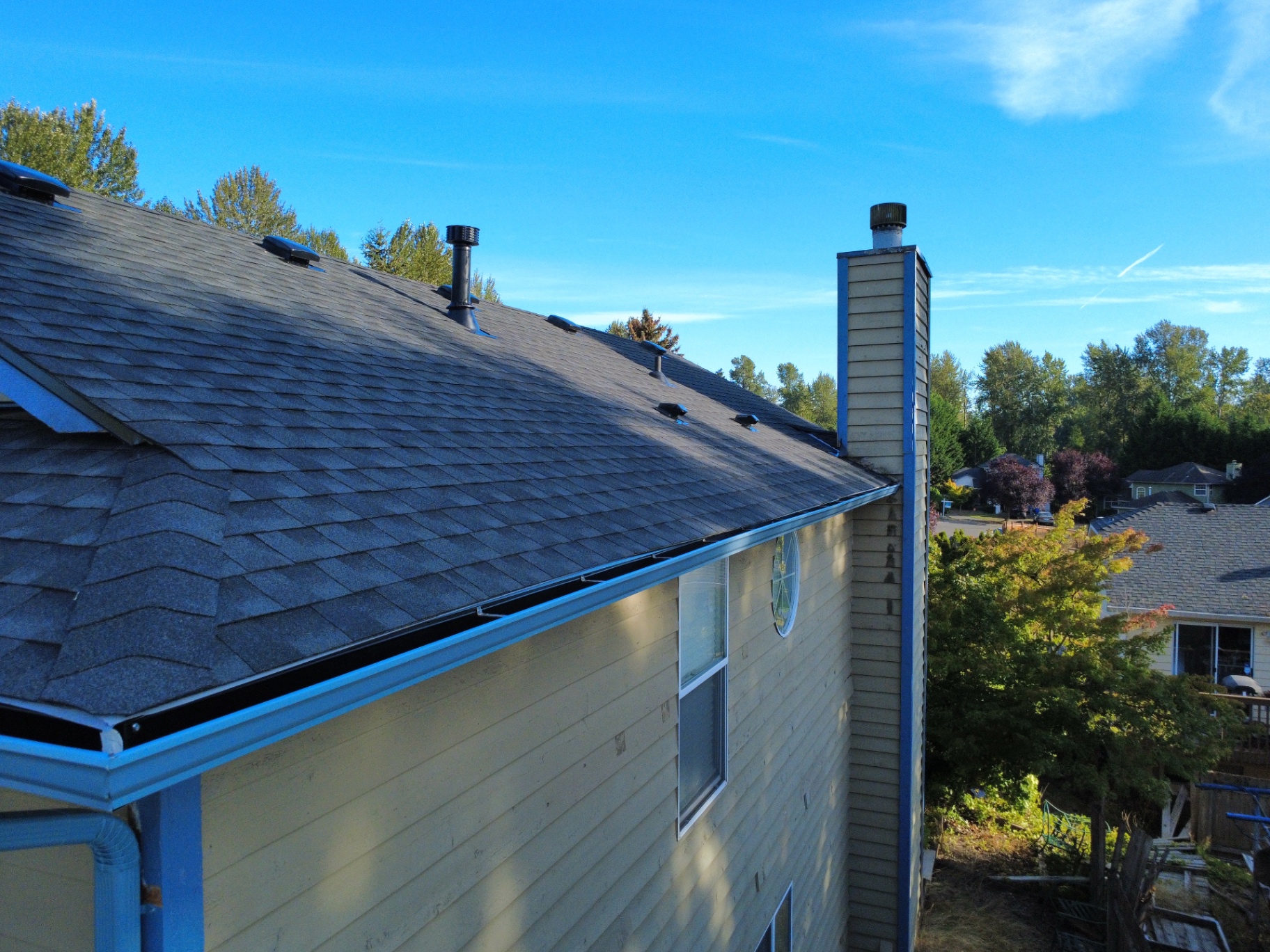Right-side aerial view of new seamless gutters along a residential roofline in Kent, Washington