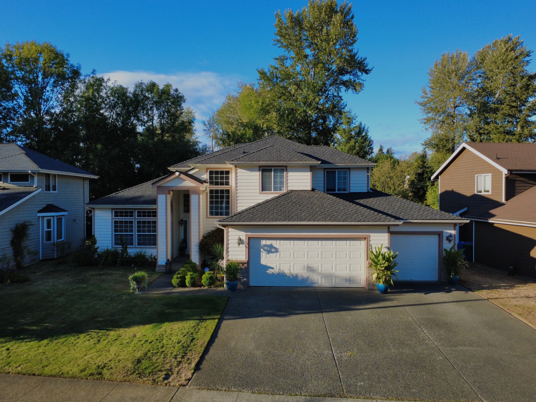 Completed charcoal-gray architectural shingle roof on a two-story suburban home in Kent, Washington
