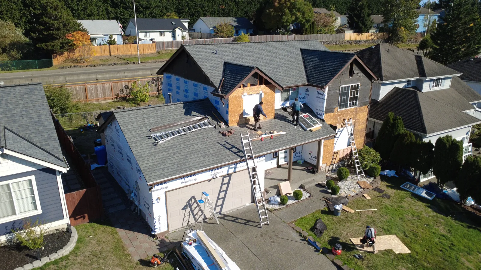 Residential exterior during renovation with visible house wrap